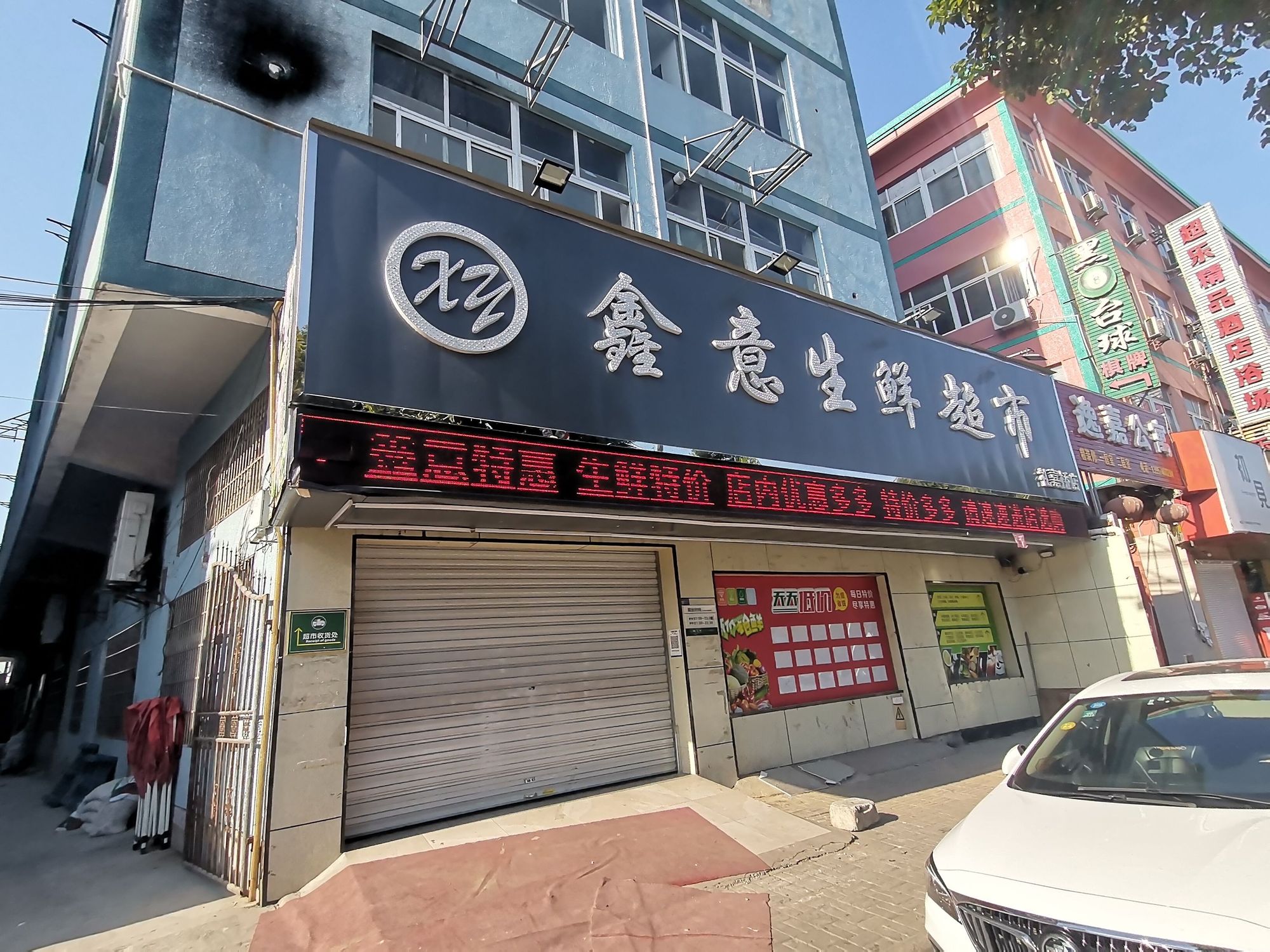 这家开在繁忙的启运路边的超市,有三间店面,门面上的电子显示